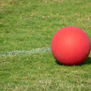 Closed shot of a red kickball in a green field
