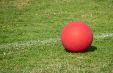 Closed shot of a red kickball in a green field