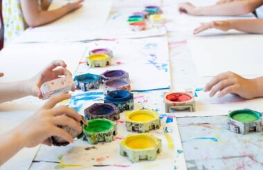Group of kids coloring with paint in summer day