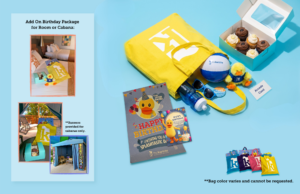 Birthday package with a yellow tote, rubber duck, card, cupcakes, sticker, ball, pin, and mini banner. Bag color may vary.